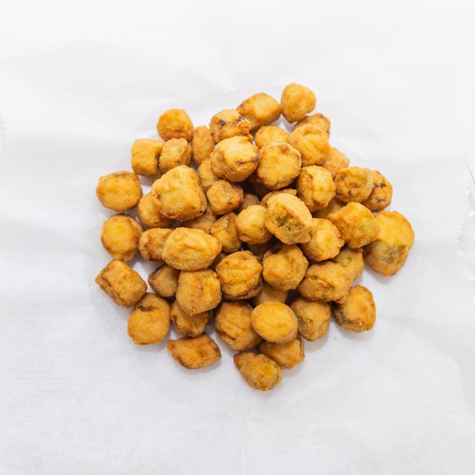 A mound of golden-brown fried bite-sized pieces rests on white paper.