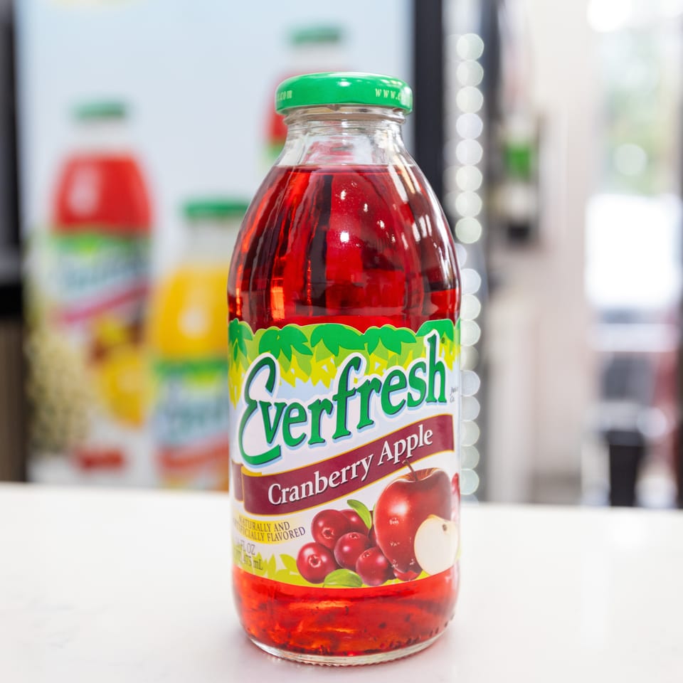 Bottle of Verifresh cranberry apple juice with a green cap displayed on a white counter.